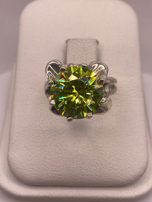 Anillo de plata solitario con circonia verde limón brillante sobre fondo blanco