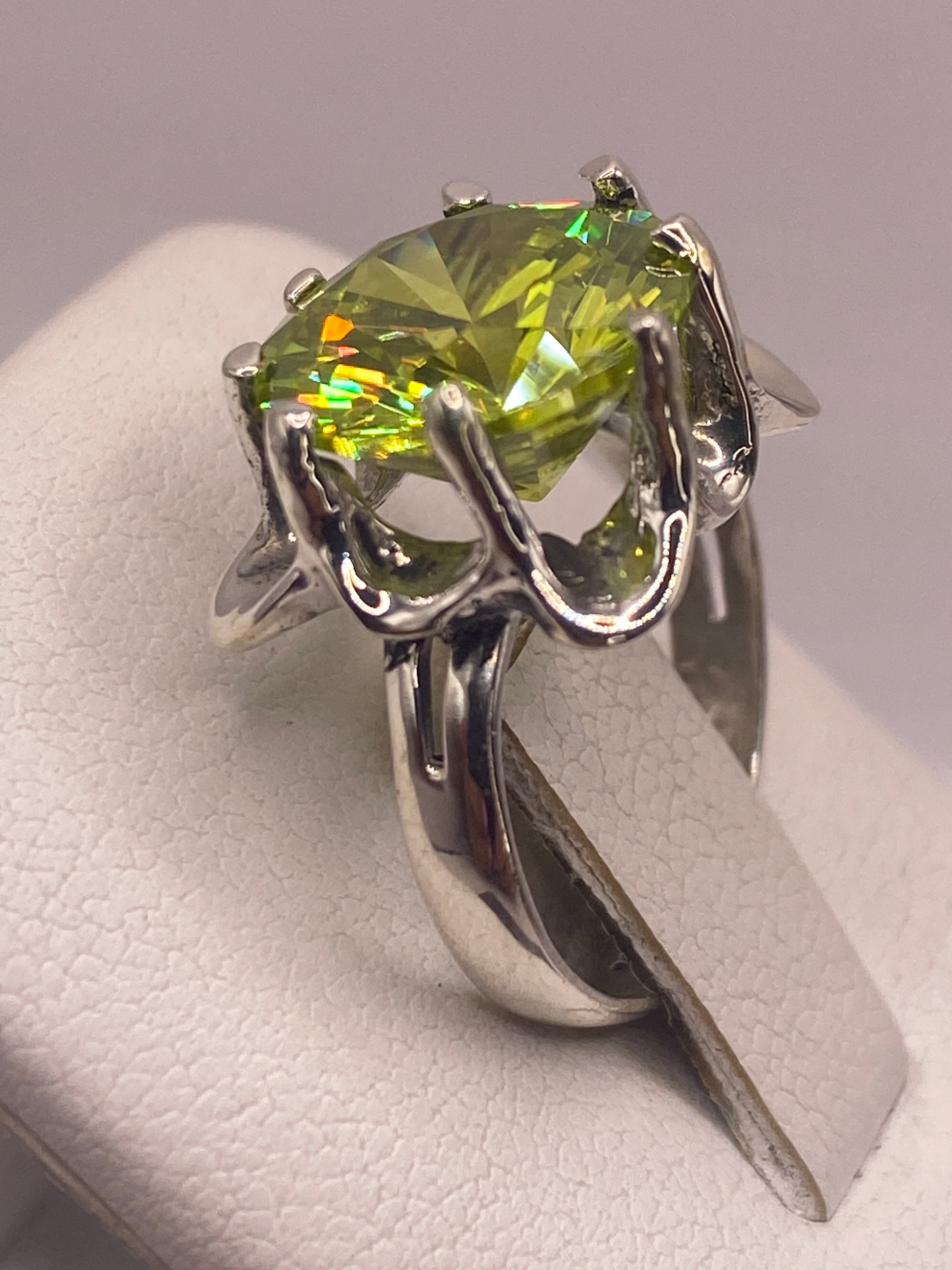 Anillo solitario verde limón colocado en dedo mostrando brillo de coctel