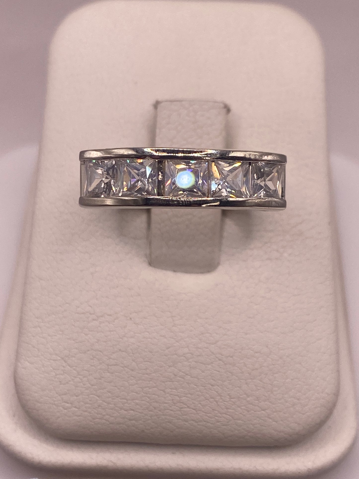 Anillo solitario de plata .925 con circonia blanca, vista frontal sobre soporte blanco