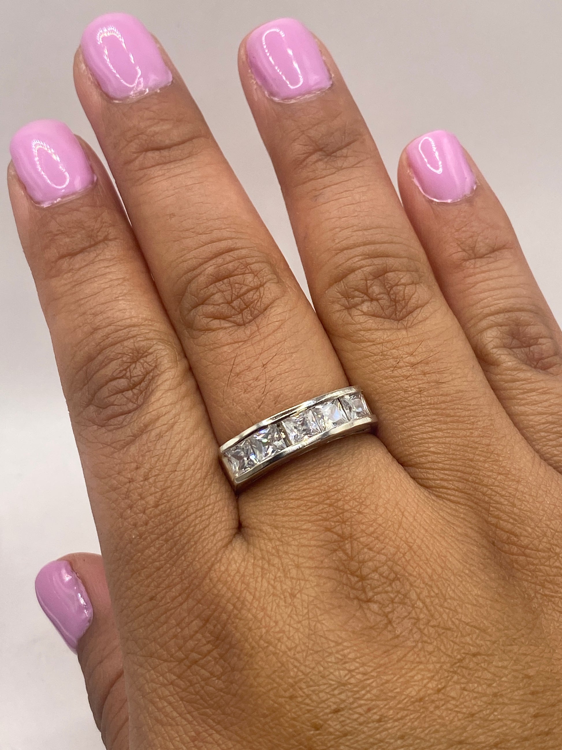 Anillo solitario minimalista de plata en la mano, con brillo diamante de la circonia
