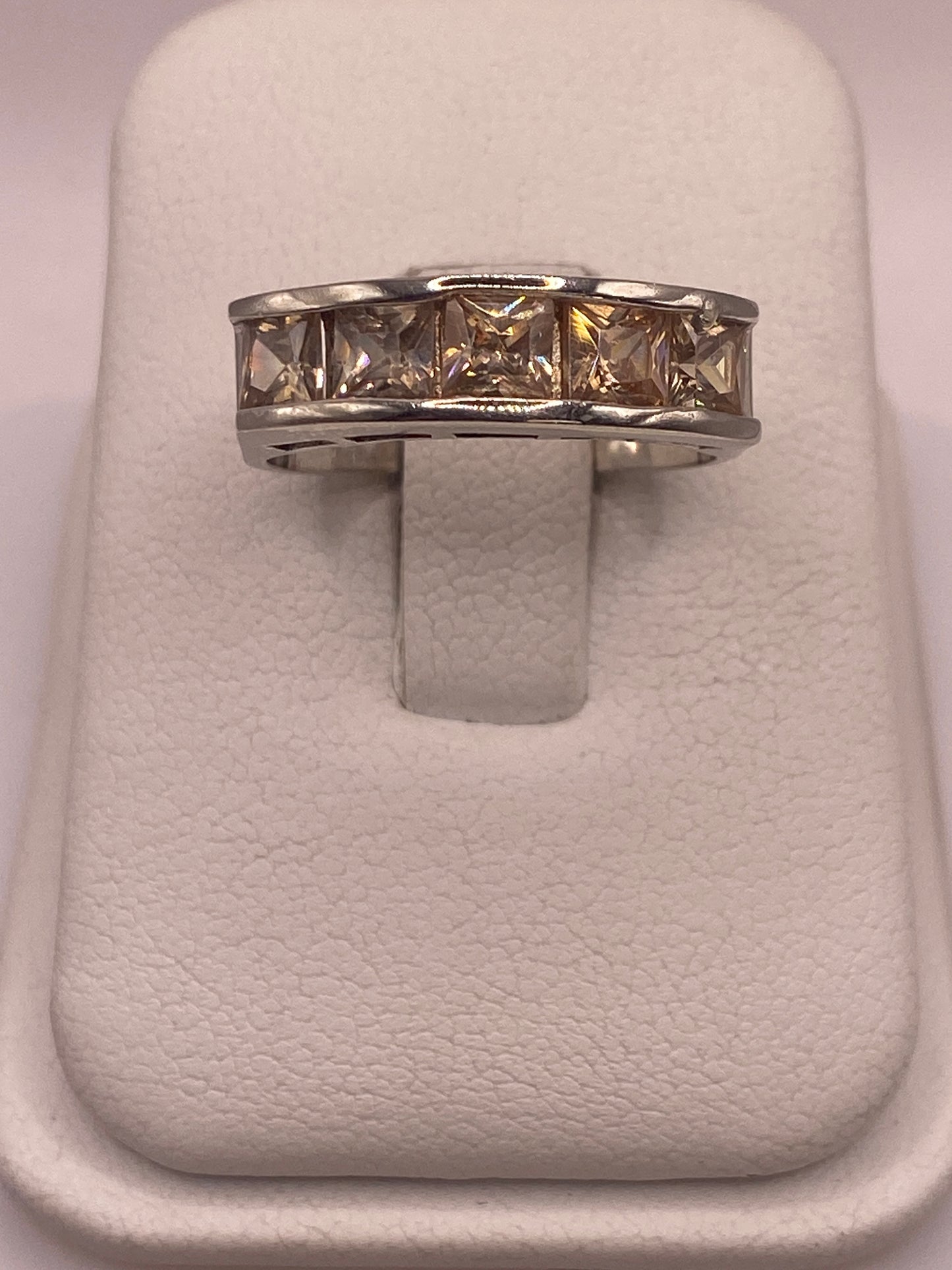 Anillo de plata .925 con circonia café en presentación de joyería sobre almohada blanca