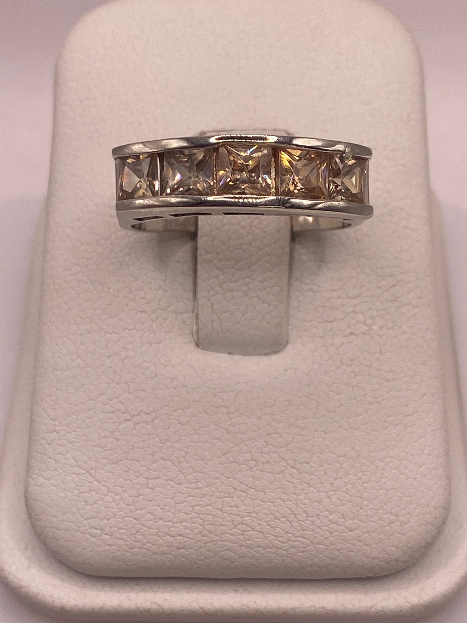 Anillo de plata .925 con circonia café en presentación de joyería sobre almohada blanca