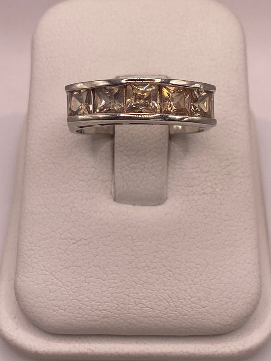 Anillo de plata .925 con circonia café en presentación de joyería sobre almohada blanca