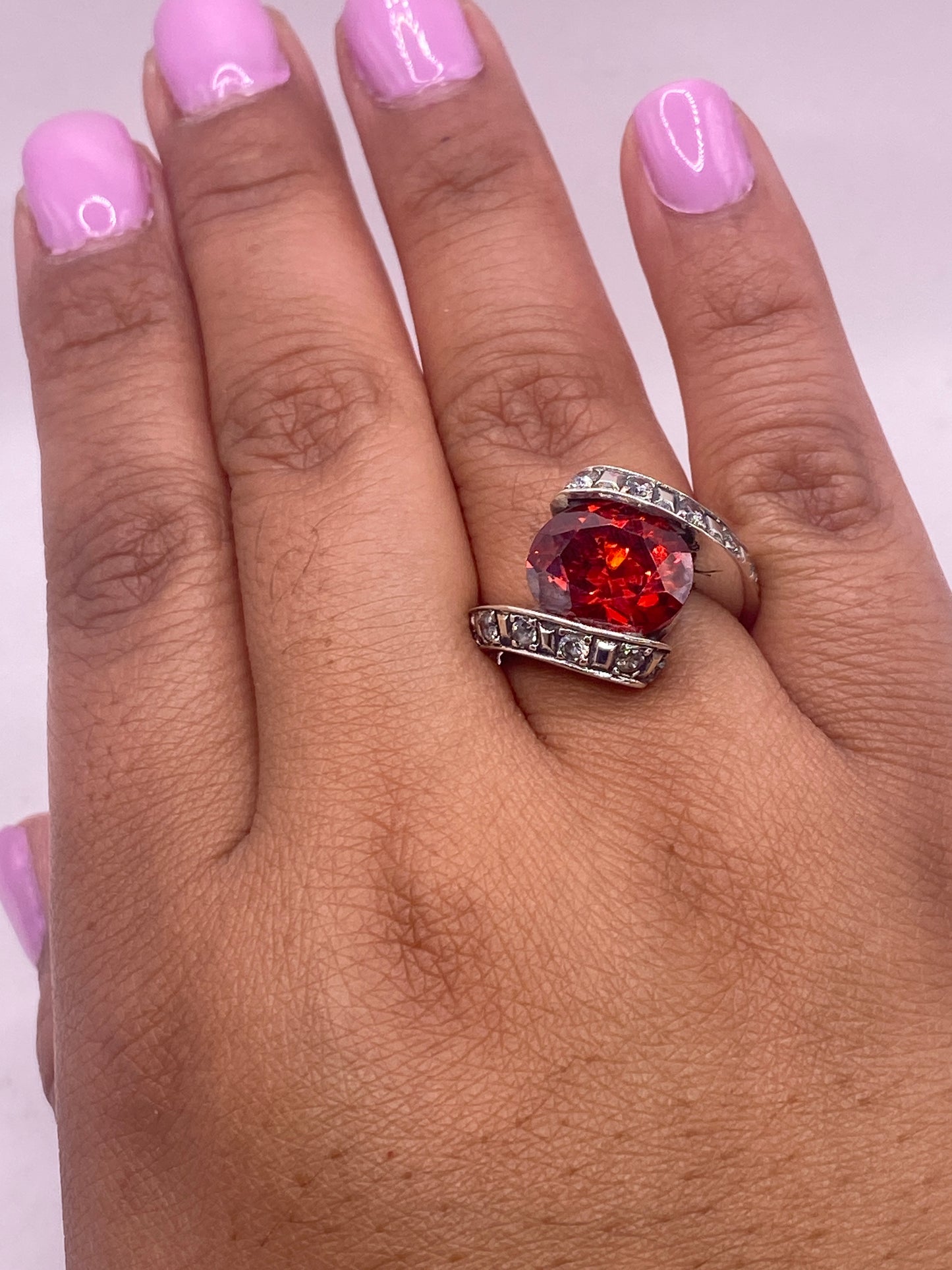 Anillo solitario naranja pesado en balanza mostrando 6.9 gramos, con sello de lote Taxco