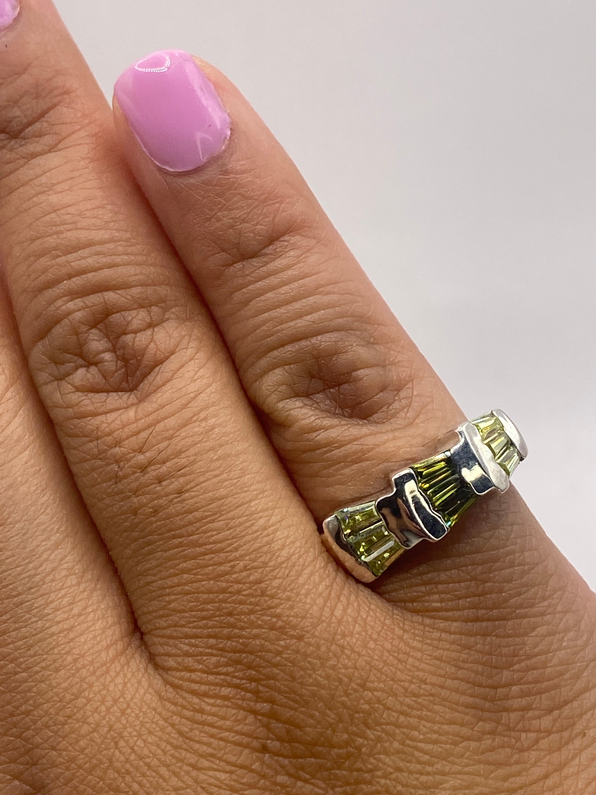 Anillo sobre dedo mostrando el efecto de luz en las piedras y el acabado pulido de la banda
