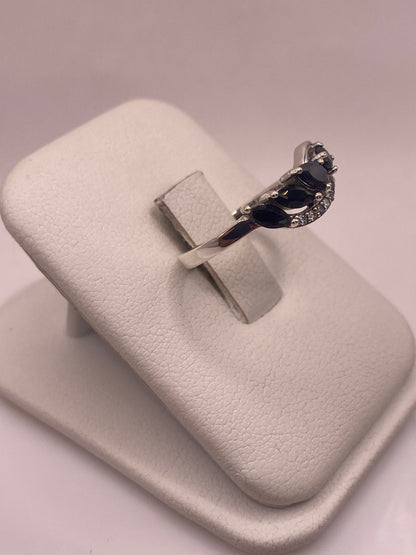 Vista frontal del anillo circonia negra mostrando el engaste plateado brillante