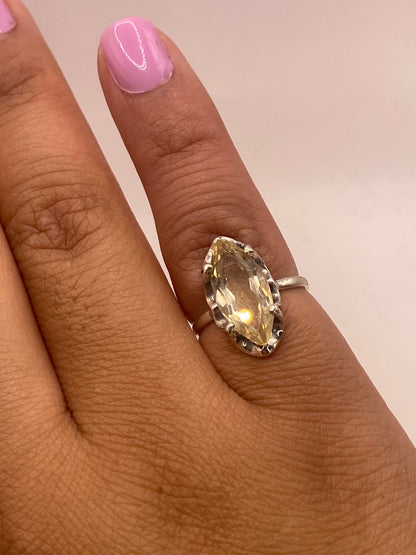 Anillo en dedo de mujer con esmalte rosa, circonia brillante amarilla visible
