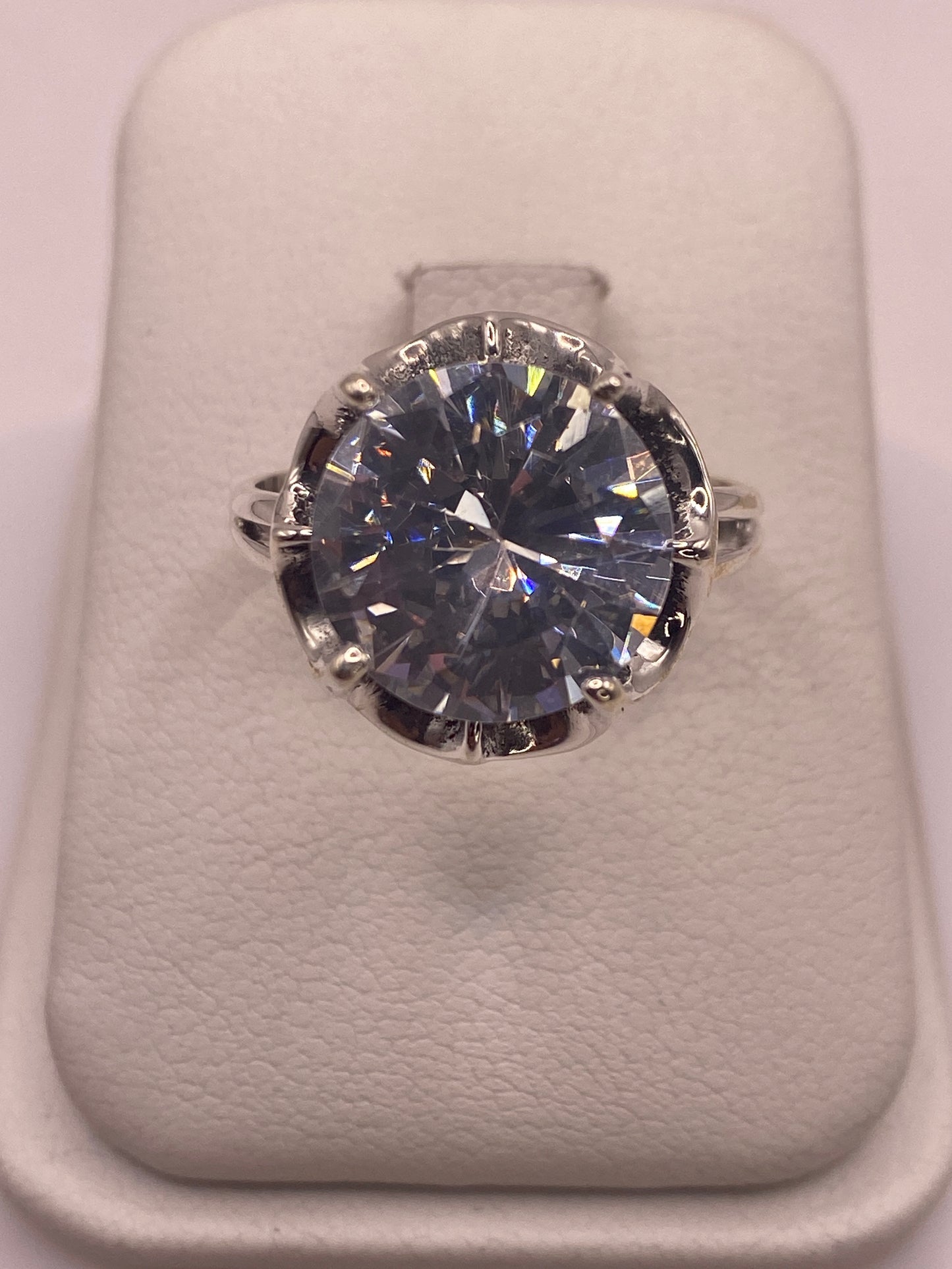 Anillo de plata .925 con solitario de circonia blanca facetada, vista frontal sobre estuche blanco