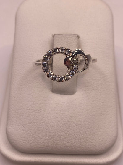 Anillo de plata solitario con circonia blanca brillante en mano de mujer con esmalte rosa