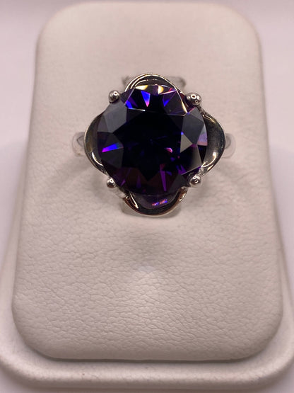 Anillo solitario de plata con circonia morada facetada sobre terciopelo blanco