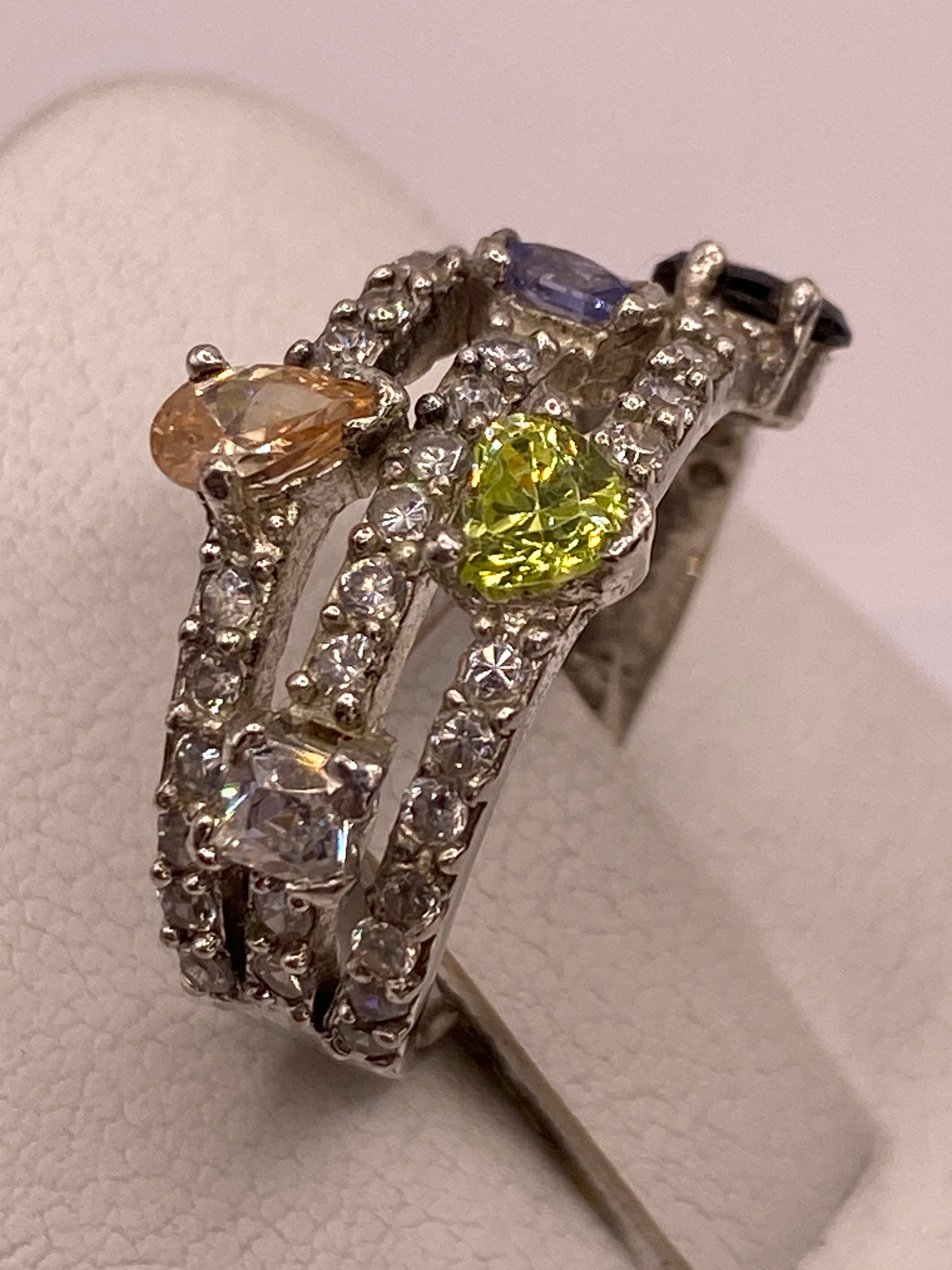 Detalle lateral del anillo mostrando el engaste de circonias y la textura de la banda