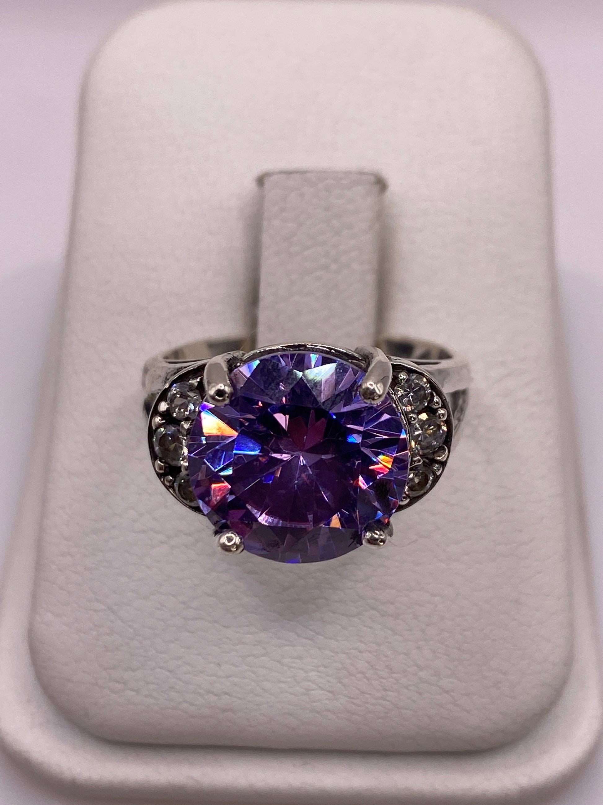 Anillo de plata .925 con circonia morada facetada en vitrina blanca, frente brillante