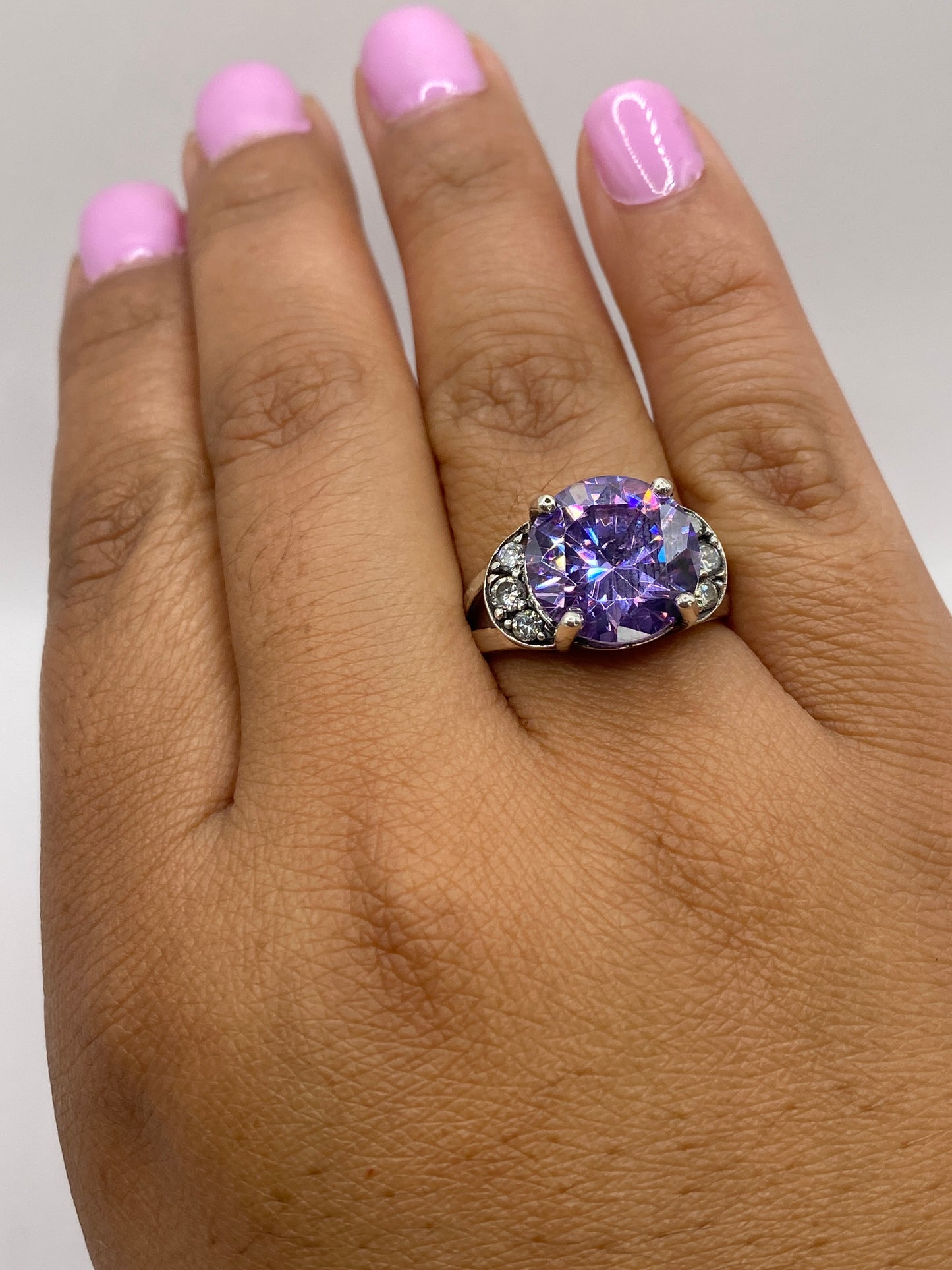 Anillo en dedo con circonia morada, mostrando el tamaño y luminosidad en piel