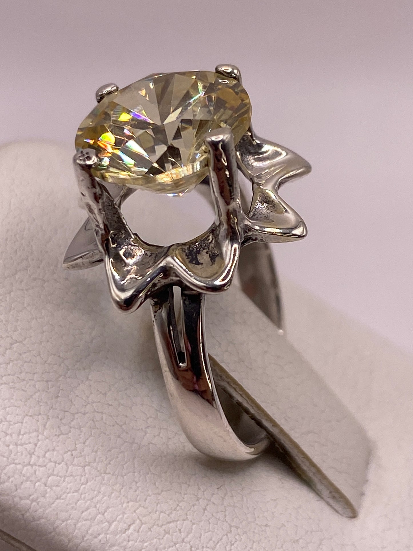 Anillo de plata en mano femenina con manicura rosa, mostrando el color cálido de la piedra