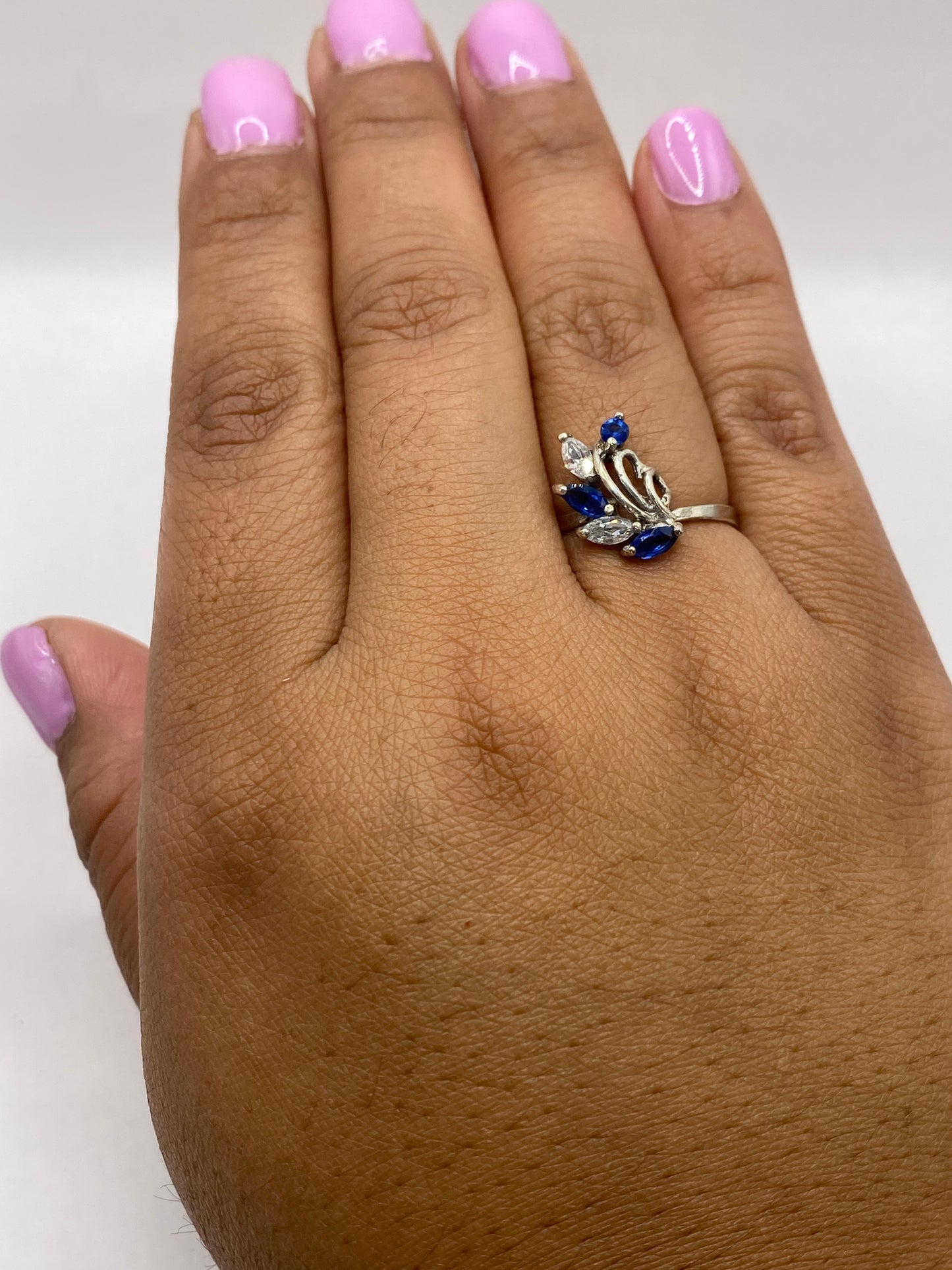 Anillo puesto en dedo con manicure rosa, luciendo elegante y minimalista