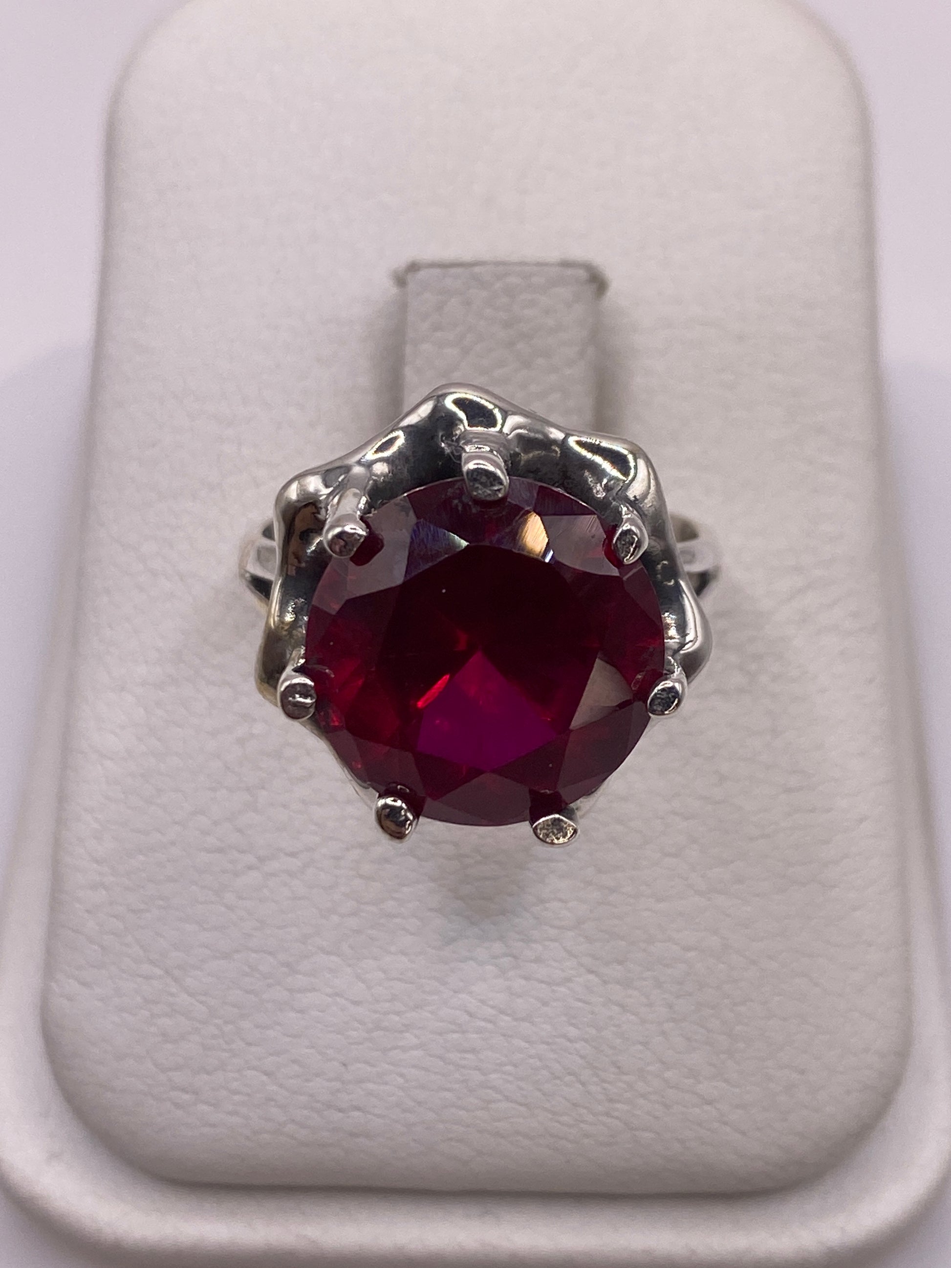 Anillo de plata con circonia rojo profundo en caja de presentación blanca