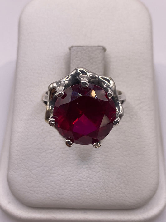 Anillo de plata con circonia rojo profundo en caja de presentación blanca