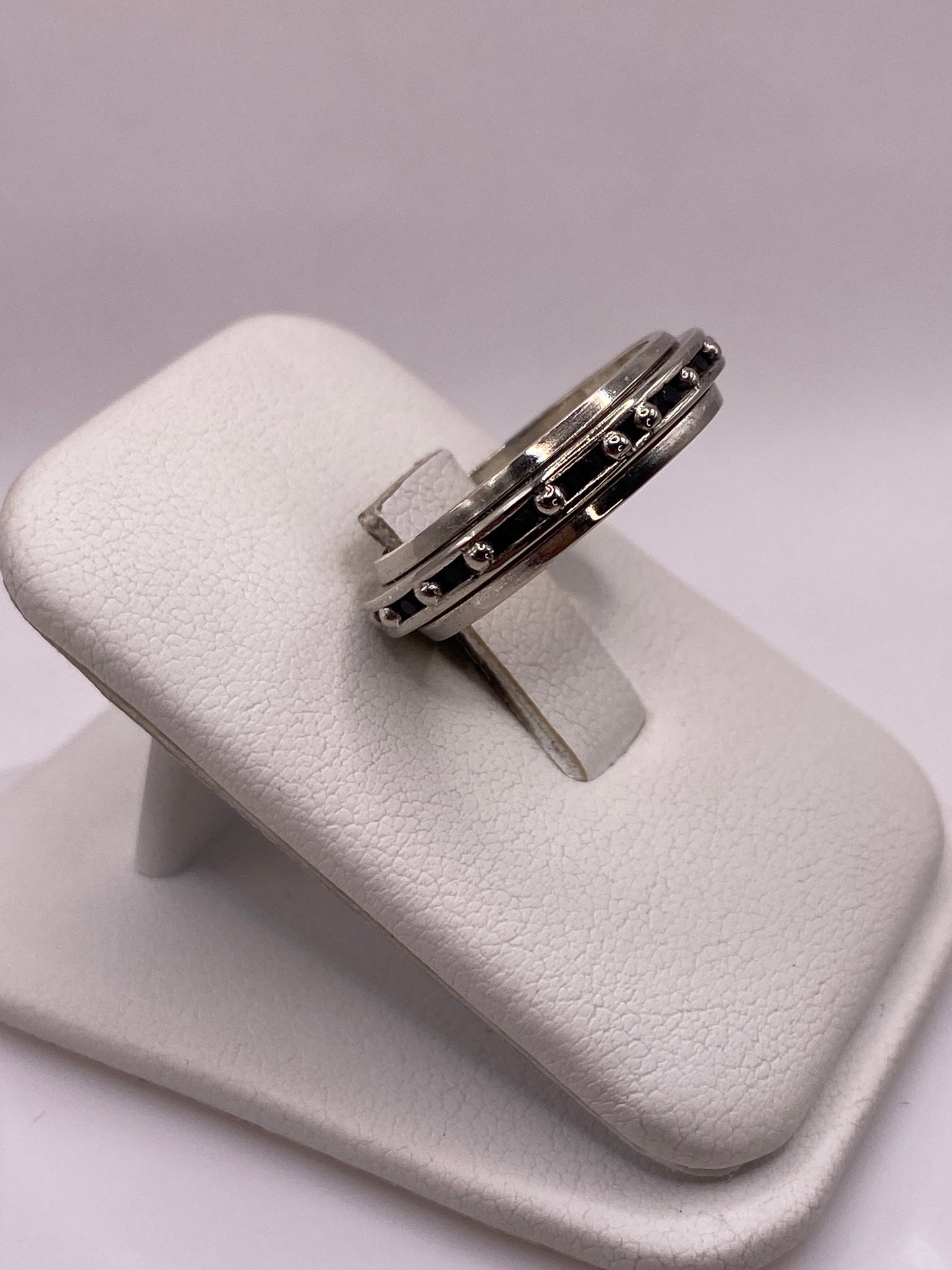 Detalle lateral del anillo mostrando banda pulida y circonia engastada