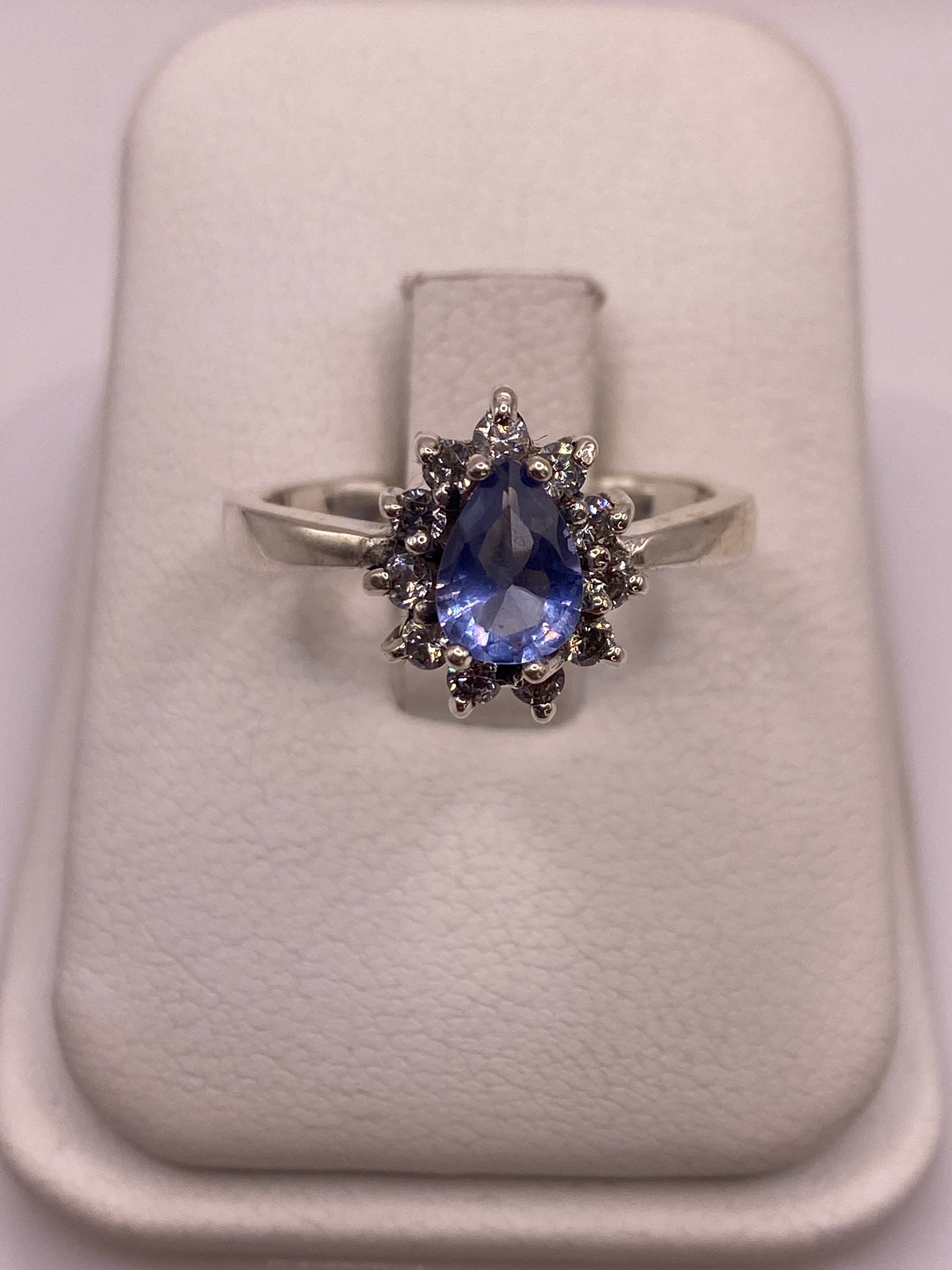 Anillo solitario de plata con circonia azul en soporte blanco, vista frontal