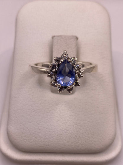 Anillo solitario de plata con circonia azul en soporte blanco, vista frontal