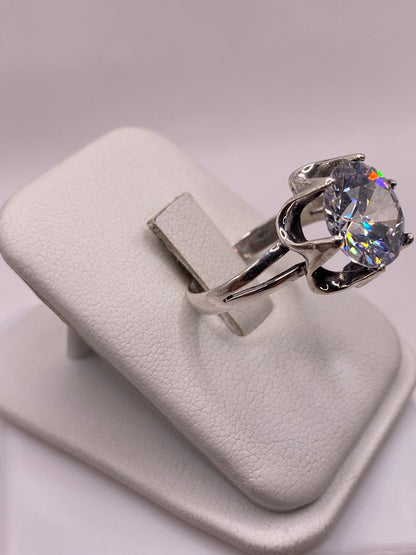 Vista lateral del anillo con corona de plata y piedra engastada en la mano