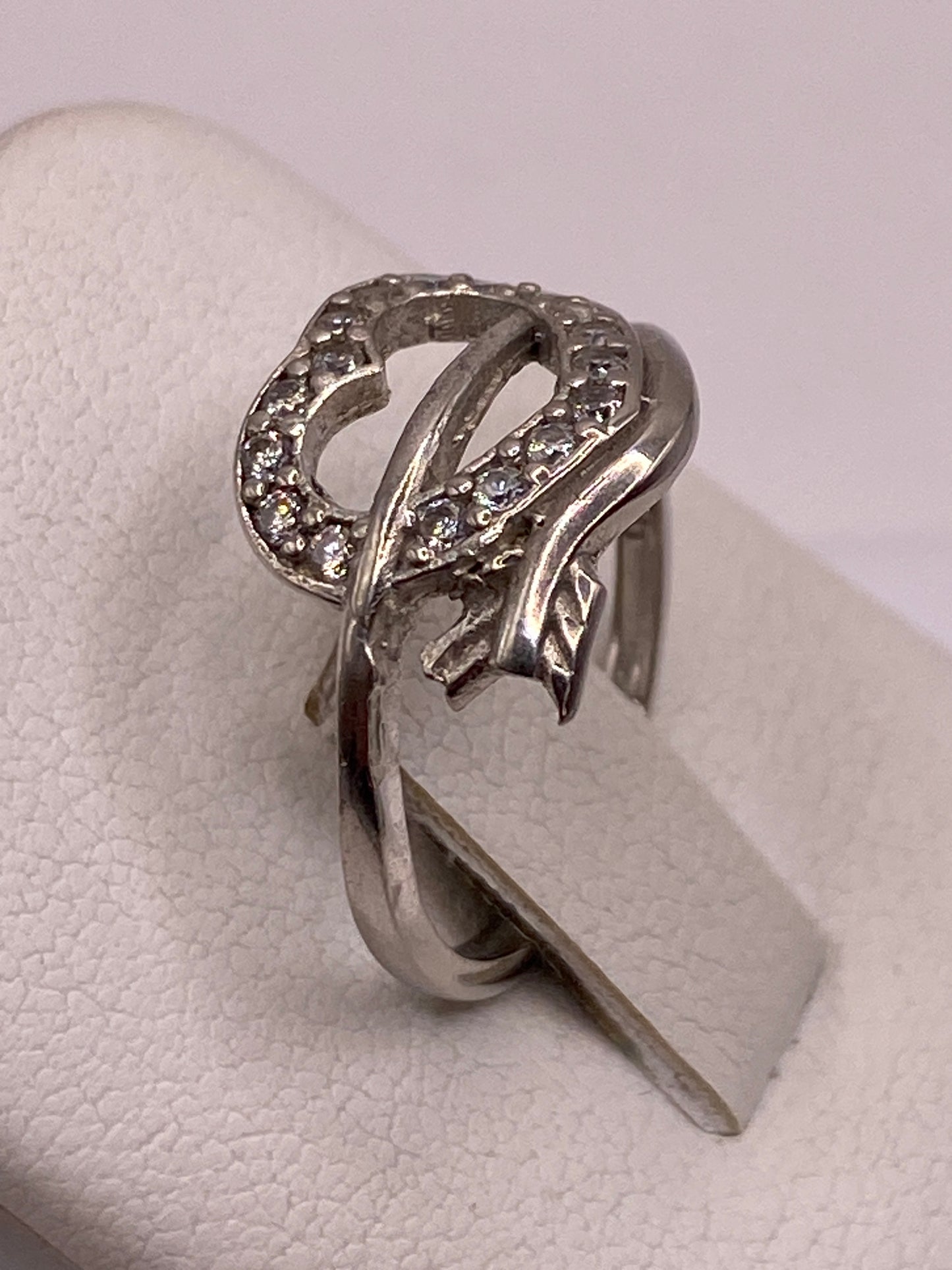 Vista lateral del anillo solitario en plata .925 sobre dedo con uñas rosas