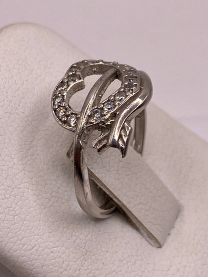 Vista lateral del anillo solitario en plata .925 sobre dedo con uñas rosas