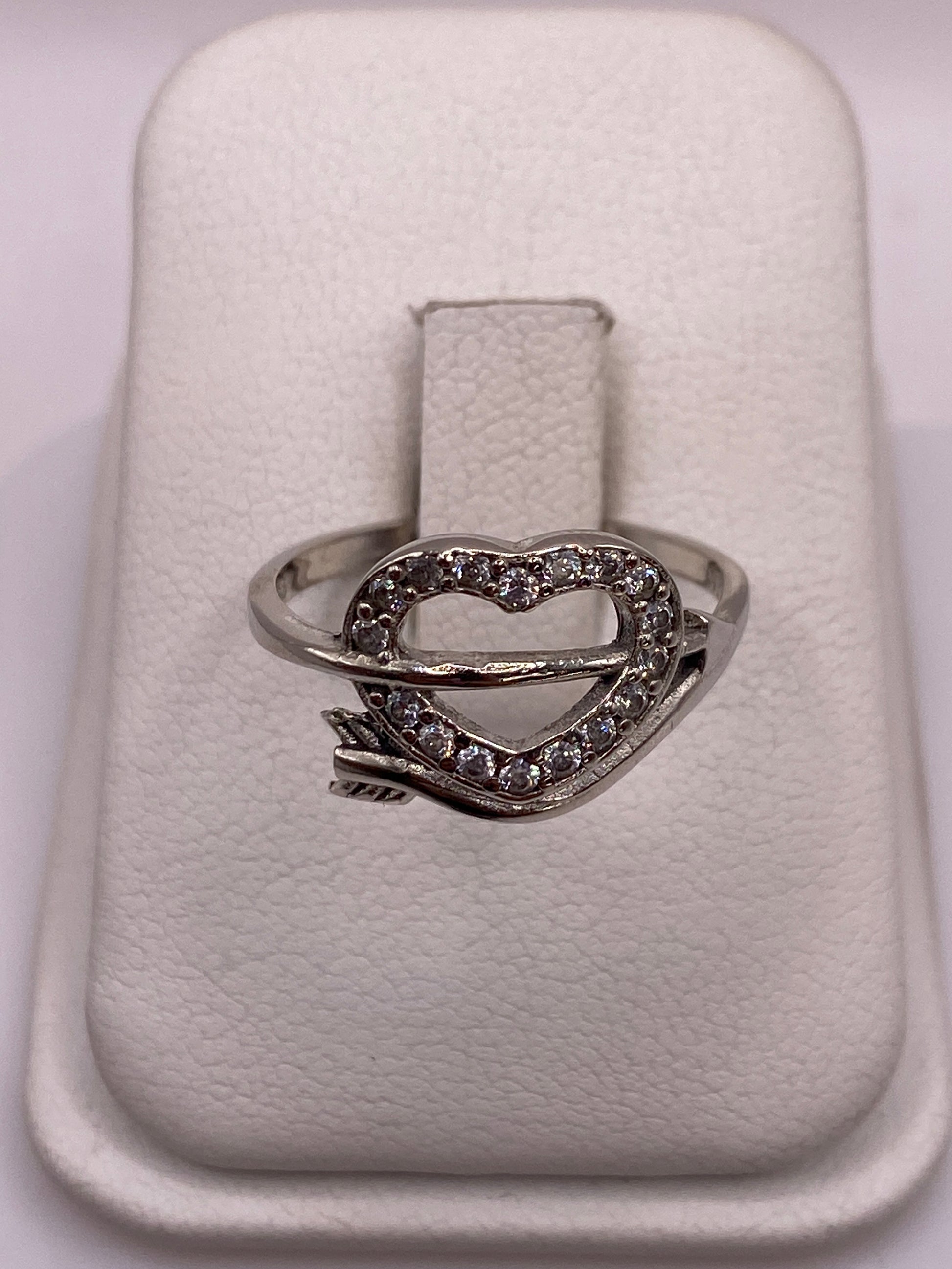 Anillo solitario de plata .925 con circonia blanca en la mano de una mujer sobre fondo blanco