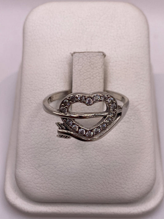 Anillo solitario de plata .925 con circonia blanca en la mano de una mujer sobre fondo blanco