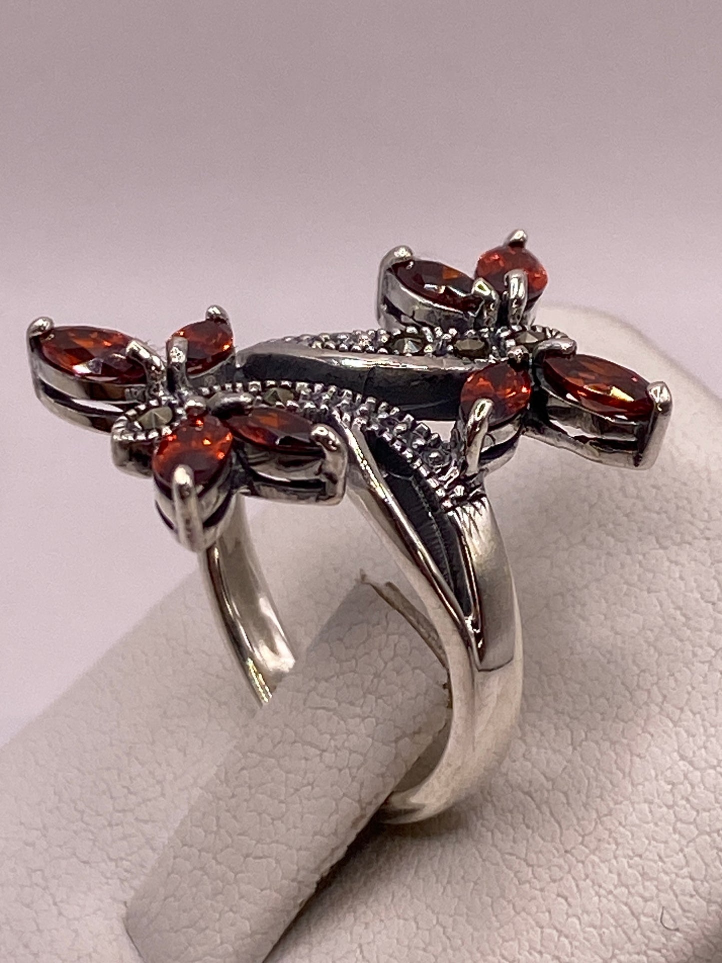 Detalle frontal del anillo mostrando las alas de circonia ámbar con fuego diamantado