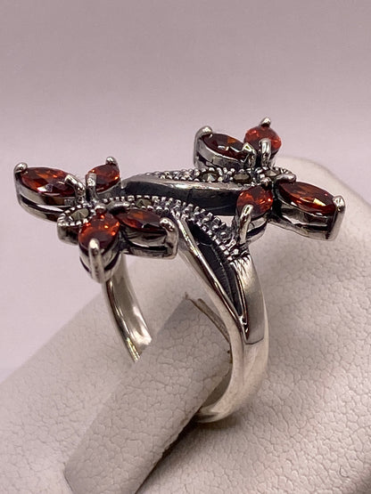 Detalle frontal del anillo mostrando las alas de circonia ámbar con fuego diamantado
