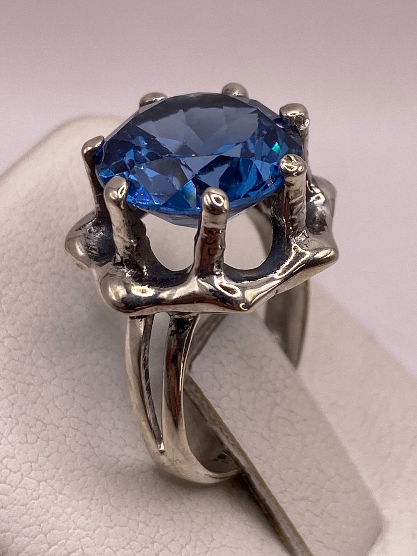 Detalle de la circonia azul facetada con brillo tipo zafiro en la mano