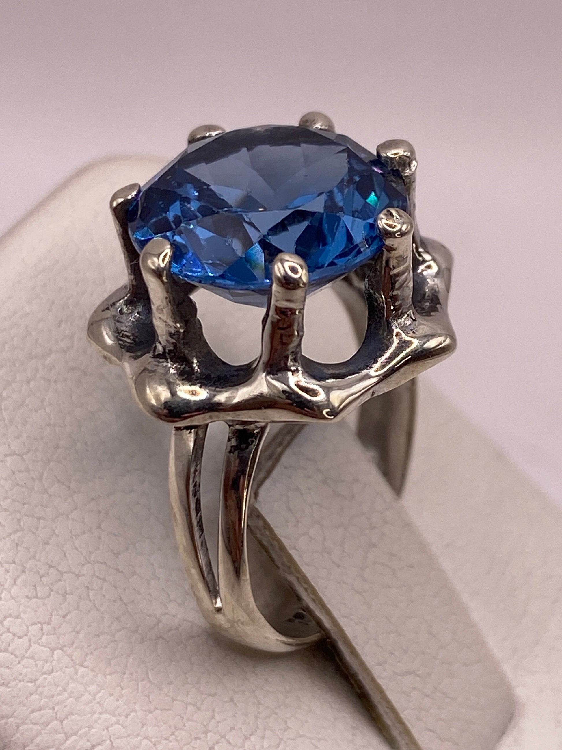 Detalle de la circonia azul facetada con brillo tipo zafiro en la mano