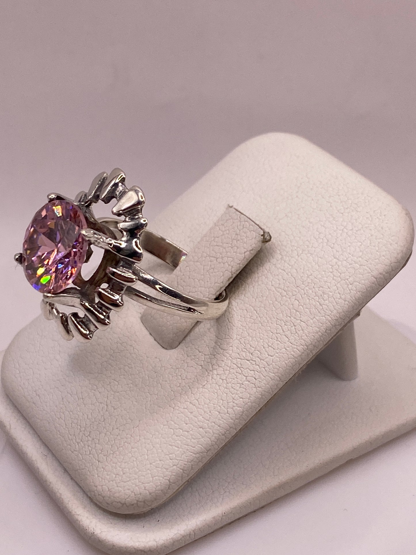 Detalle lateral del anillo solitario mostrando la circonia rosa y brillo de fuego