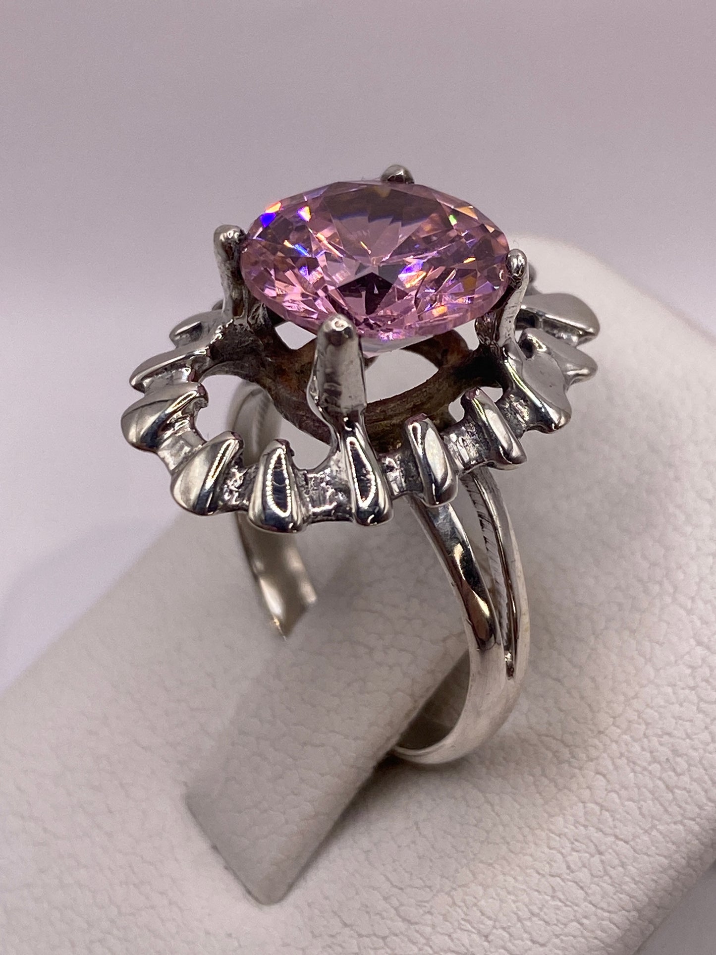 Anillo de circonia rosa puesto en mano de mujer sobre estuche