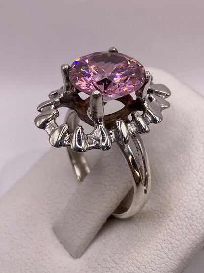 Anillo de circonia rosa puesto en mano de mujer sobre estuche