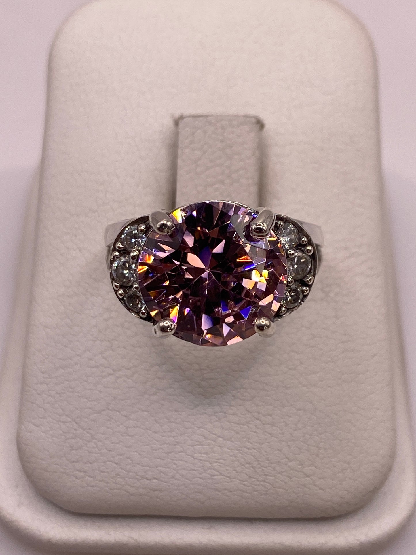 Anillo solitario de plata con circonia rosa facetada en engaste de corona, sobre dedo