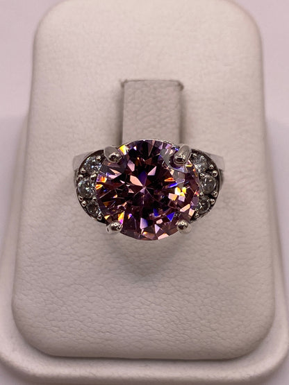 Anillo solitario de plata con circonia rosa facetada en engaste de corona, sobre dedo