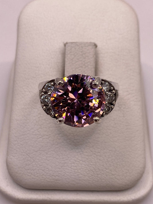 Anillo solitario de plata con circonia rosa facetada en engaste de corona, sobre dedo