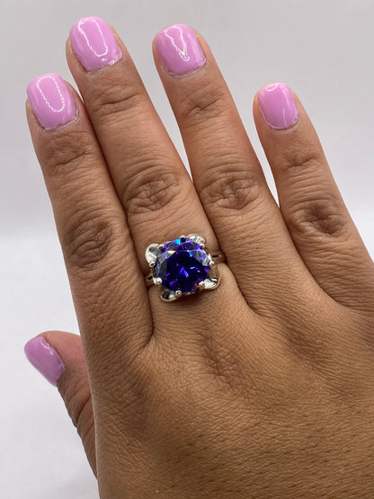 Anillo puesto en mano mostrando el brillo y fuego de la circonia morada