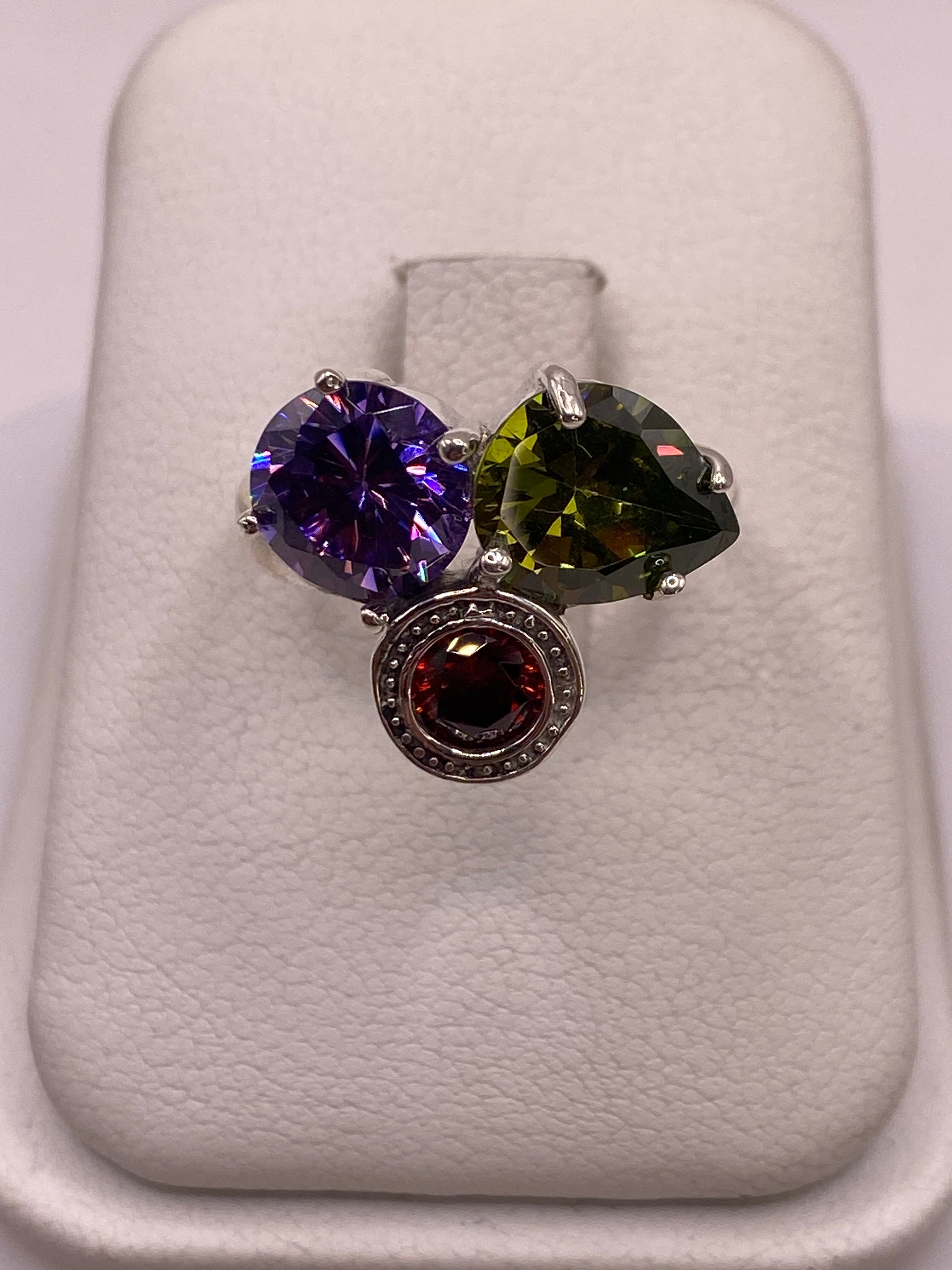 Anillo de plata con tres circonias multicolor (púrpura, verde oliva, rojo) en cortes brillantes