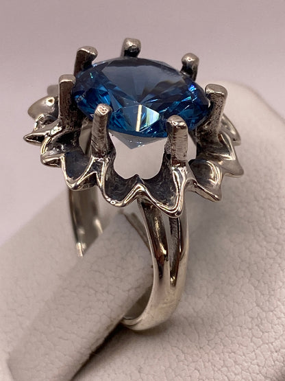 Anillo de circonia azul en la mano de una mujer, vista frontal