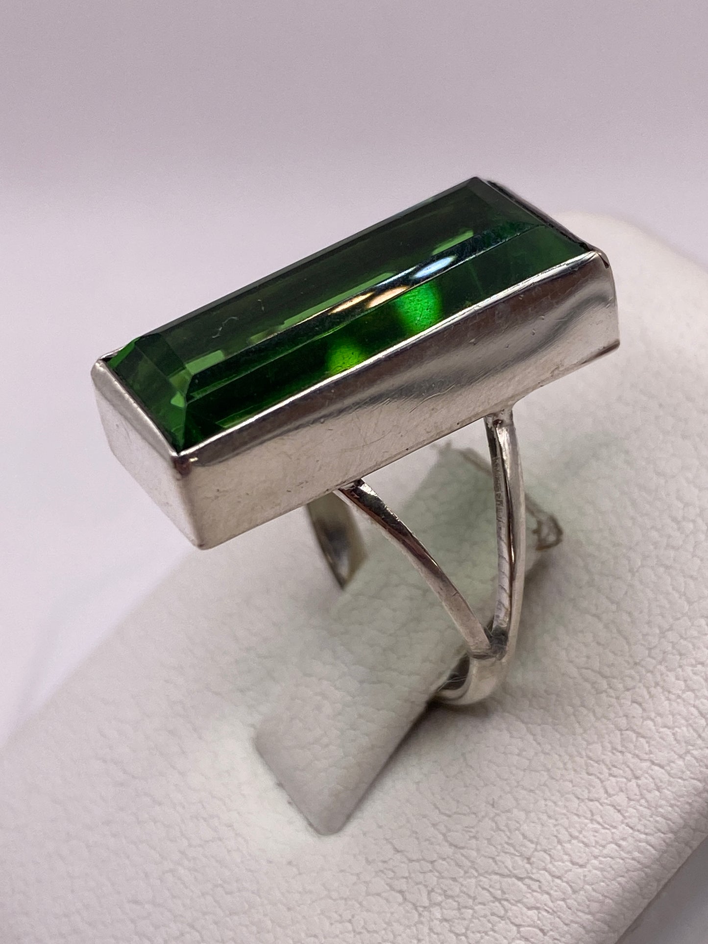 Detalle del engaste en bisel de plata alrededor de la circonia verde