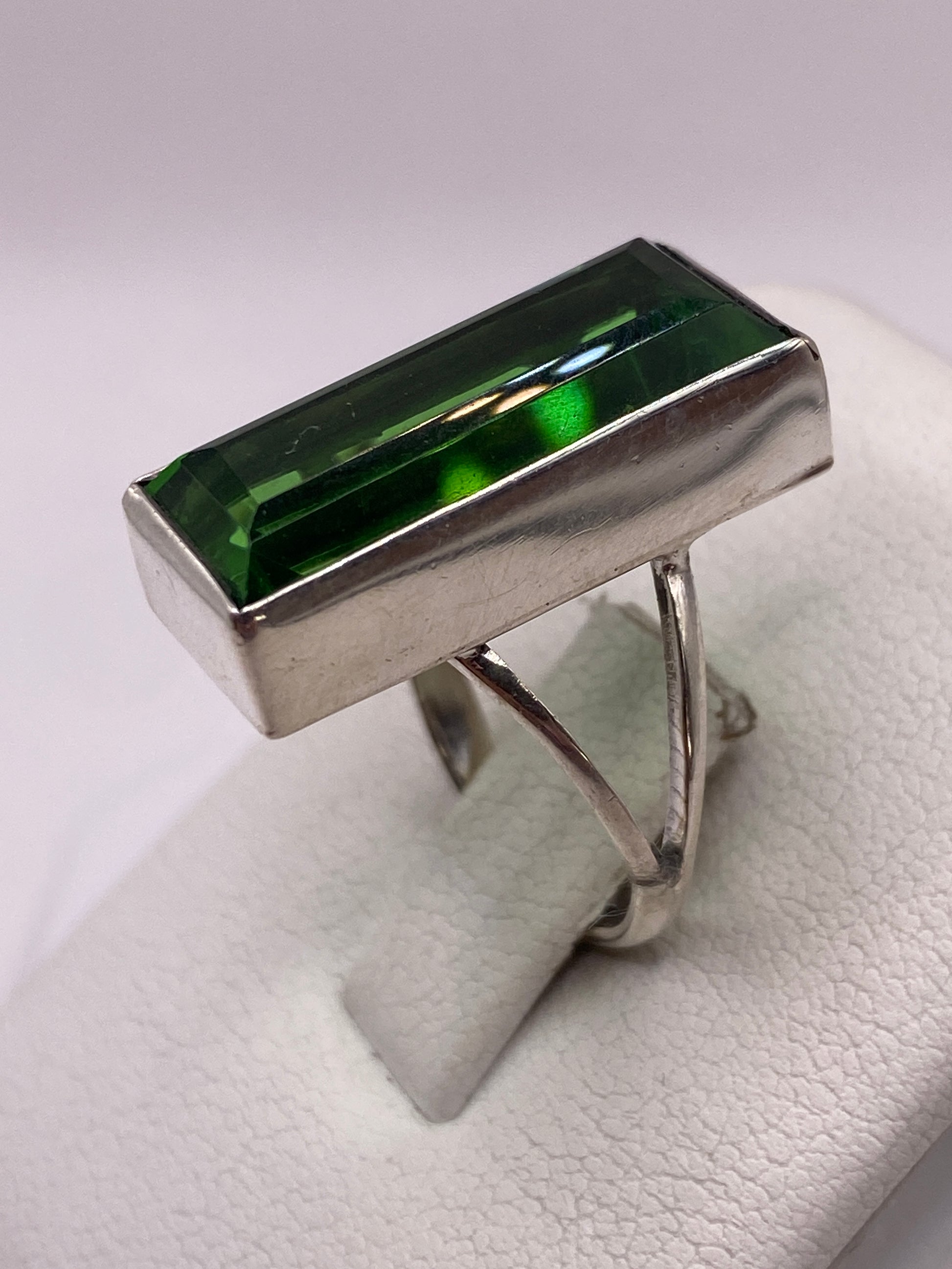 Detalle del engaste en bisel de plata alrededor de la circonia verde