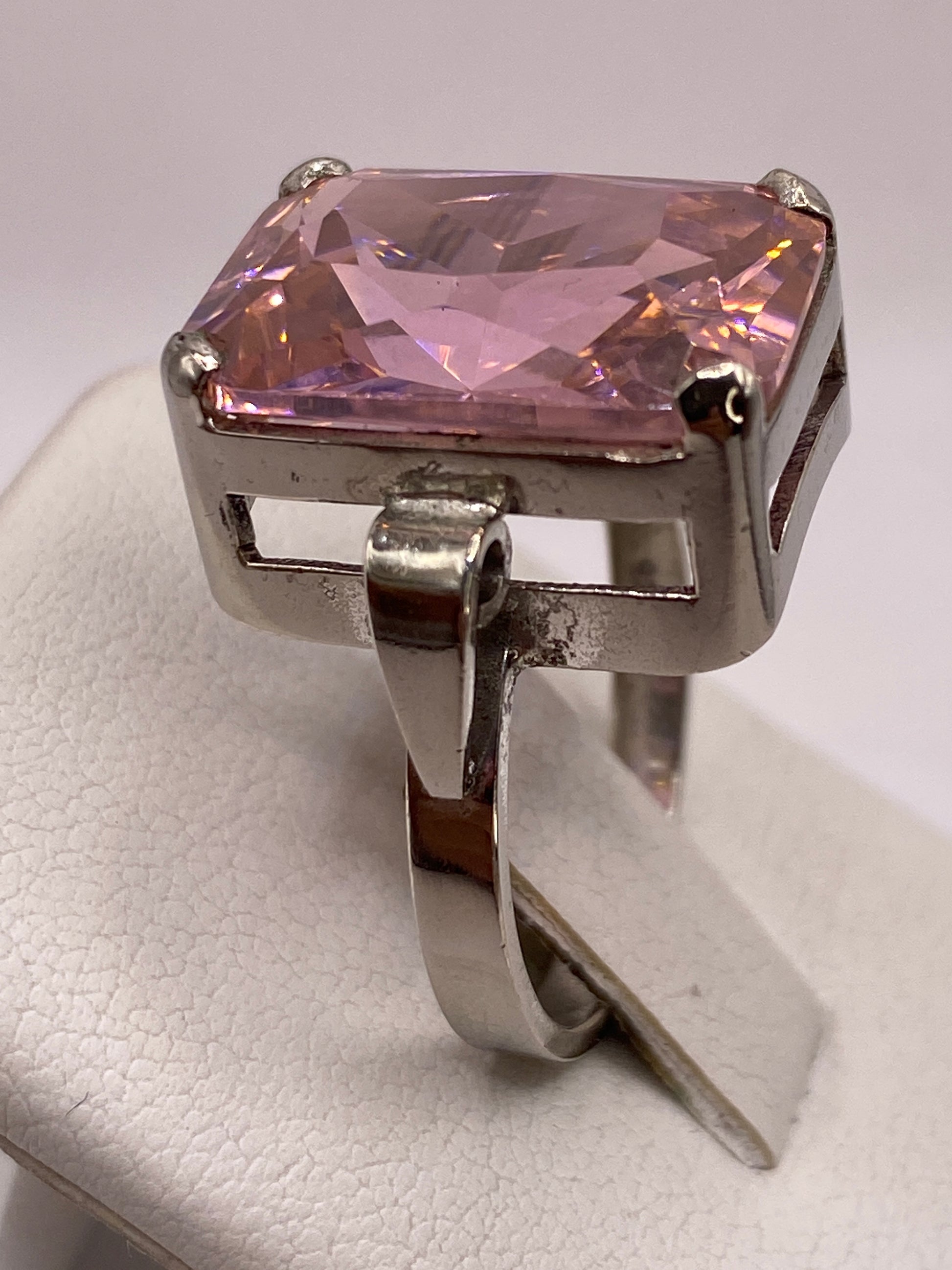 Anillo rosa brillante en la mano de una mujer con esmalte rosa