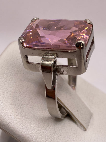 Anillo rosa brillante en la mano de una mujer con esmalte rosa