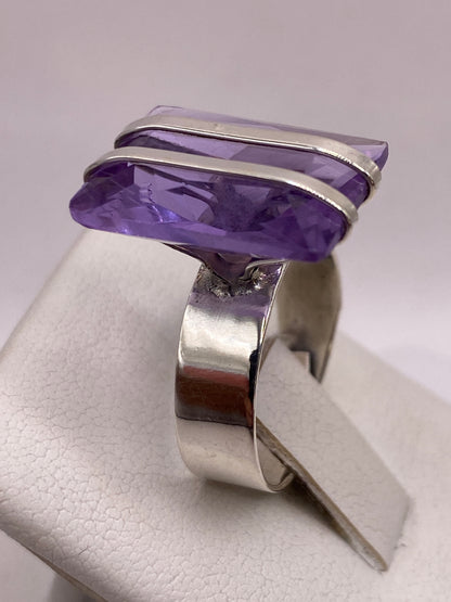 Detalle lateral del anillo ajustable de plata morada contra fondo neutro
