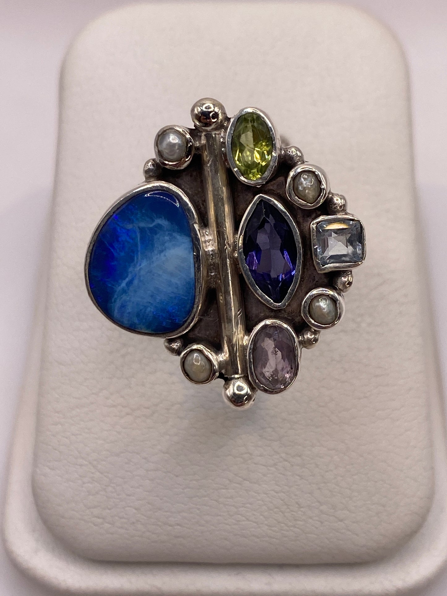 Anillo de plata geométrico con circonias azul, verde, blanca y púrpura engastadas a mano