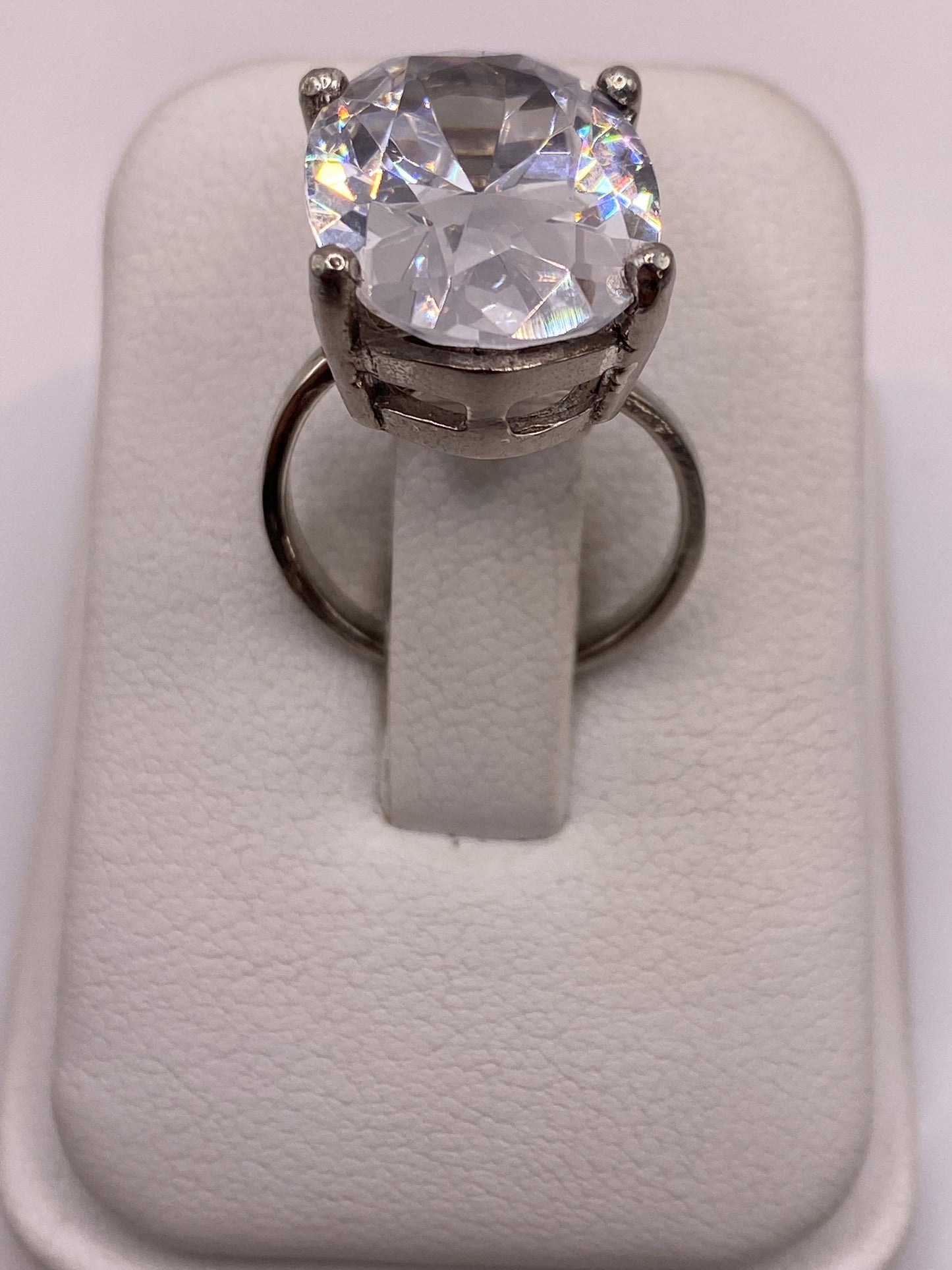 Anillo solitario ajustable con circonia blanca brillante en plata .925, vista frontal en estuche blanco
