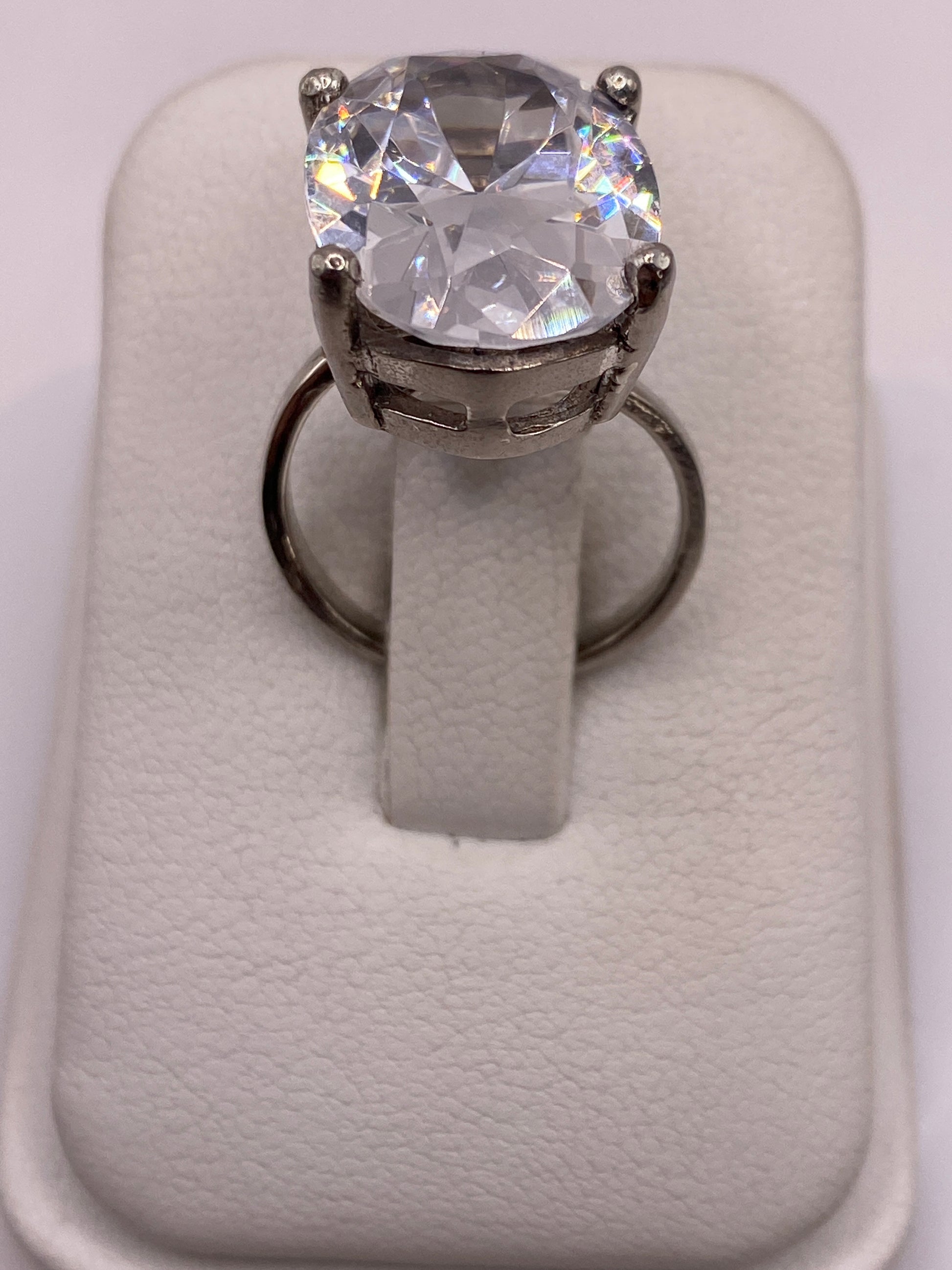 Anillo solitario ajustable con circonia blanca brillante en plata .925, vista frontal en estuche blanco